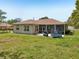 A spacious backyard features green grass, a screened patio, and ample space for outdoor activities at 2016 Alameda Dr, Spring Hill, FL 34609