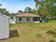A spacious backyard features green grass, a screened patio, and ample space for outdoor activities at 2016 Alameda Dr, Spring Hill, FL 34609