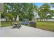 Enjoy the spacious backyard with outdoor patio set, outdoor kitchen, grill, trampoline and mature trees at 2016 Alameda Dr, Spring Hill, FL 34609