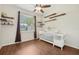 Bedroom with wood-look flooring, ceiling fan, wall-mounted shelves, and a crib by a bright window at 2016 Alameda Dr, Spring Hill, FL 34609