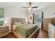 This bedroom features wood floors, a ceiling fan, large dresser and window view of the front yard at 2016 Alameda Dr, Spring Hill, FL 34609