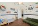 Charming bedroom featuring car themed decorations, ceiling fan, wood-look tile, and a cozy green couch at 2016 Alameda Dr, Spring Hill, FL 34609