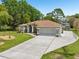 Charming single-story home featuring a manicured lawn, a two car garage, and decorative landscape beds at 2016 Alameda Dr, Spring Hill, FL 34609