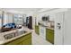Open-concept kitchen with green cabinets, granite countertops, and stainless steel appliances; open to the living area at 2016 Alameda Dr, Spring Hill, FL 34609
