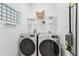 Laundry room with front-load washer and dryer set, built-in shelves, and a convenient calendar for planning at 2016 Alameda Dr, Spring Hill, FL 34609