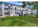 Expansive backyard view of a well-maintained lawn with lush landscaping, creating a serene outdoor space at 2042 Australia W Way # 12, Clearwater, FL 33763