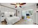 Bright bedroom with white comforter bed, sleek ceilings fan and frosted sliding glass door to a sitting room at 2042 Australia W Way # 12, Clearwater, FL 33763