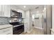 Bright kitchen featuring stainless steel appliances, modern white cabinets, and tile backsplash at 2042 Australia W Way # 12, Clearwater, FL 33763