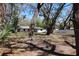Backyard with mature trees providing shade, a white vinyl fence, and a glimpse of the home's exterior at 2105 Curry Rd, Lutz, FL 33549