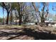 Lush backyard with mature shade trees and a white vinyl fence surrounding the property at 2105 Curry Rd, Lutz, FL 33549