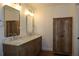 Bathroom features a double sink vanity with marble countertop and cabinet for storage at 2105 Curry Rd, Lutz, FL 33549