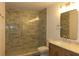 Modern bathroom featuring a glass enclosed shower with decorative tile and vanity with marble countertop at 2105 Curry Rd, Lutz, FL 33549