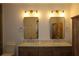 Bathroom featuring a marble countertop and dual vanity sinks with a wooden cabinet at 2105 Curry Rd, Lutz, FL 33549