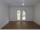 A bright bedroom with hardwood floors, white walls, ceiling fan and glass patio doors at 2105 Curry Rd, Lutz, FL 33549