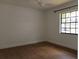 Bedroom with wood floors, ceiling fan, and a large window at 2105 Curry Rd, Lutz, FL 33549