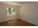 Bright bedroom featuring hardwood floors, a ceiling fan, and a large window offering ample natural light at 2105 Curry Rd, Lutz, FL 33549