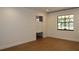 Bright bedroom featuring hardwood floors, white walls, and a window with black trim at 2105 Curry Rd, Lutz, FL 33549