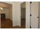 Hallway with wood floors shows passage between rooms and to a bedroom at 2105 Curry Rd, Lutz, FL 33549