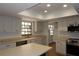 Bright kitchen featuring white cabinets, stainless steel appliances, an island, and a skylight at 2105 Curry Rd, Lutz, FL 33549