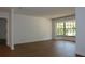 Spacious living room with hardwood flooring, freshly painted walls, and a large window with black trim at 2105 Curry Rd, Lutz, FL 33549