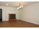 Living room featuring a brick fireplace, hardwood floors and modern light fixture at 2105 Curry Rd, Lutz, FL 33549