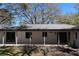 Rear exterior features a covered patio with access from multiple doors and backyard with shade trees at 2105 Curry Rd, Lutz, FL 33549
