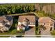 An aerial view of an upscale neighborhood featuring manicured lawns, mature trees, and scenic water views at 21867 Amelia Rose Way, Land O Lakes, FL 34637