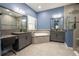 Bathroom featuring a soaking tub, dual vanities, framed mirrors, tiled shower, and blue walls at 21867 Amelia Rose Way, Land O Lakes, FL 34637