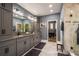 Bathroom featuring granite countertops, dual sinks, and gray cabinets and tiled floors with a view to the bedroom at 21867 Amelia Rose Way, Land O Lakes, FL 34637