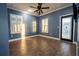 Bright bedroom with wood tile flooring, two windows with shutters, and a ceiling fan at 21867 Amelia Rose Way, Land O Lakes, FL 34637