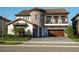 Beautiful two-story home showcasing a stone tower, tile roof, balcony, manicured landscaping, and brick driveway at 21867 Amelia Rose Way, Land O Lakes, FL 34637
