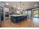 Open eat-in kitchen showcasing an oversized island with seating, stainless appliances, and wood flooring at 21867 Amelia Rose Way, Land O Lakes, FL 34637