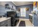 Well-organized laundry room with gray cabinets, shelving, and modern black washer and dryer at 21867 Amelia Rose Way, Land O Lakes, FL 34637