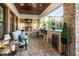Covered outdoor kitchen boasts a built-in grill, bar seating, and a cozy lounge area at 21867 Amelia Rose Way, Land O Lakes, FL 34637