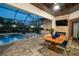 Inviting screened-in pool area with dining and lounge areas, including a fireplace at 21867 Amelia Rose Way, Land O Lakes, FL 34637