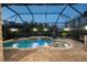 Beautiful screened-in pool featuring a waterfall, in-pool seating and view of the backyard at 21867 Amelia Rose Way, Land O Lakes, FL 34637