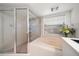Bathroom features walk-in shower with glass door, soaking tub, and window at 307 Oleander Rd, Belleair, FL 33756