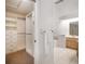Main bathroom with walk-in closet, large tub, walk-in shower, and white tiled floors at 307 Oleander Rd, Belleair, FL 33756
