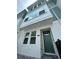 Exterior of townhome featuring a green front door, gray brick pavers, and light teal and white accents at 3113 4Th N Ter, St Petersburg, FL 33713