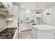 Modern kitchen with stainless steel appliances, gray backsplash, white cabinets and island, and wood floors at 3113 4Th N Ter, St Petersburg, FL 33713