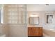 Bright bathroom with a wooden vanity, tiled walls, and a glass block wall feature at 3171 Roxmere Dr, Palm Harbor, FL 34685