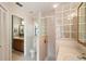 Well-lit bathroom with a wooden vanity, glass block shower, and tiled walls at 3171 Roxmere Dr, Palm Harbor, FL 34685