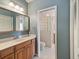 Bright bathroom with a wood vanity, large mirror, and a unique glass block shower at 3171 Roxmere Dr, Palm Harbor, FL 34685
