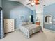 Comfortable bedroom featuring blue walls, a ceiling fan, and a decorative bedspread at 3171 Roxmere Dr, Palm Harbor, FL 34685