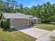 Well-maintained home featuring an attached two-car garage and a long concrete driveway at 3171 Roxmere Dr, Palm Harbor, FL 34685