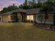 Dusk view of a well-maintained home featuring manicured landscaping and a spacious lawn at 3171 Roxmere Dr, Palm Harbor, FL 34685
