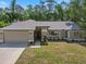 Charming one-story home with a manicured lawn, two car garage, and front landscaping at 3171 Roxmere Dr, Palm Harbor, FL 34685