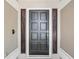 Close-up of a classic black front door with detailed gold hardware and sidelights at 3171 Roxmere Dr, Palm Harbor, FL 34685