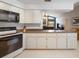 Bright kitchen featuring white cabinetry, stone countertops and views of living area at 3171 Roxmere Dr, Palm Harbor, FL 34685