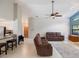 Spacious living room with tile flooring, fan, and seamless access to kitchen at 3171 Roxmere Dr, Palm Harbor, FL 34685